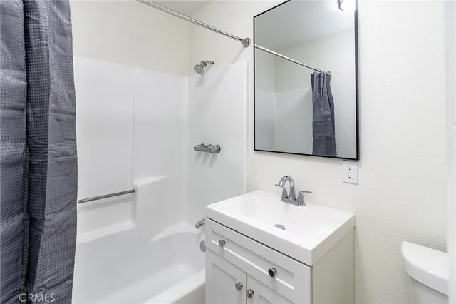 an empty room with a window and a ceiling fan