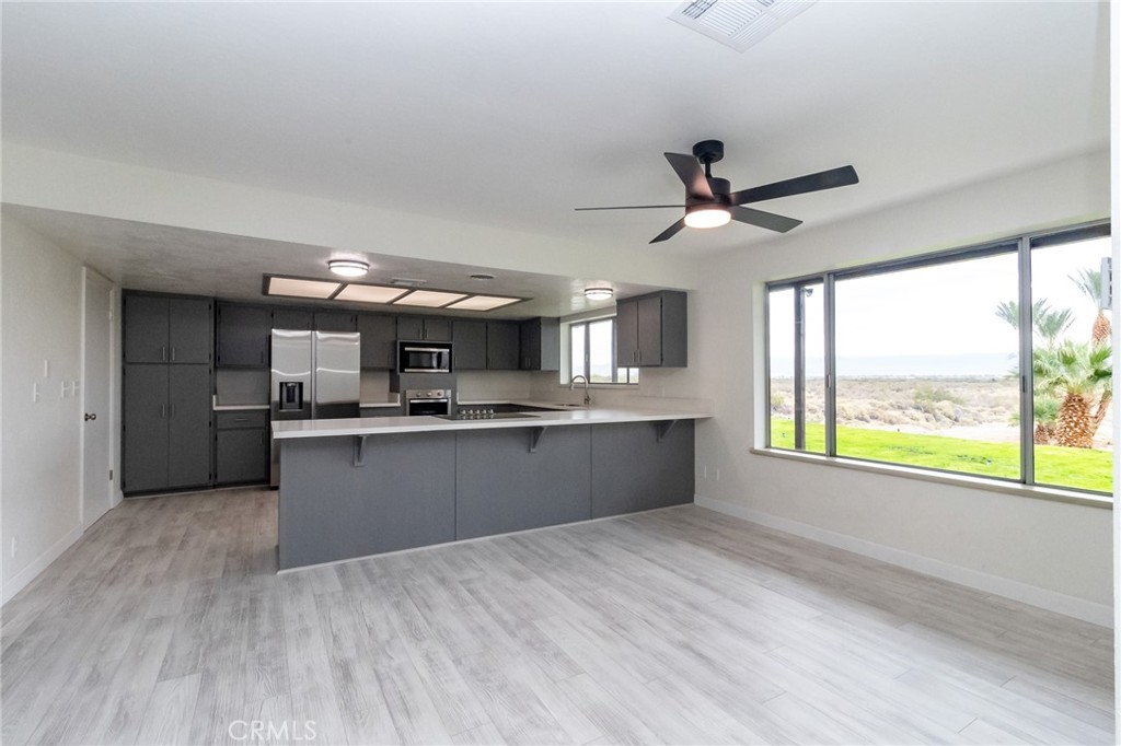 1507 David Drive Needles, CA 92363 - Photo 10 of 44 a large kitchen with stainless steel appliances kitchen island a large counter space a sink a window and cabinets