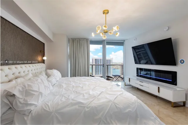 a spacious bedroom with a bed and a flat screen tv