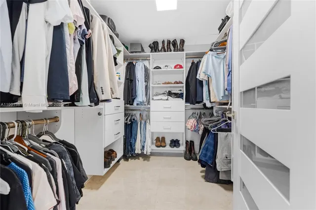 a view of walk in closet with clothes and shoes