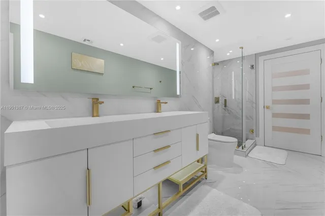 a bathroom with a sink a toilet and shower