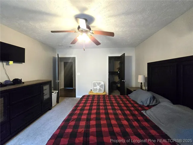 a bedroom with a bed and a flat tv screen on dresser