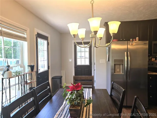 a dining room with furniture a chandelier and wooden floor