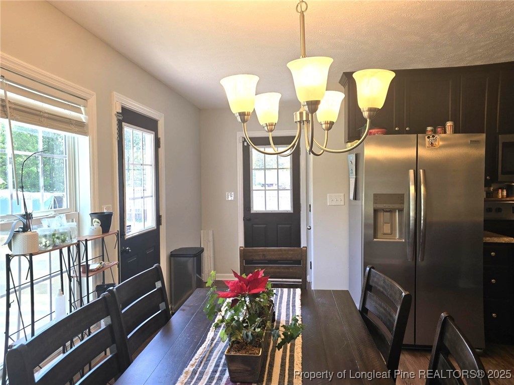 5345 Pittman Grove Church Road Raeford, NC 28376 - Photo 10 of 45 a dining room with furniture a chandelier and wooden floor