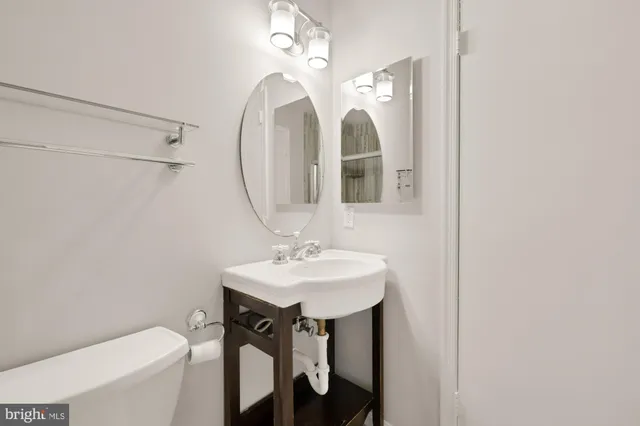 a bathroom with a sink mirror vanity and toilet