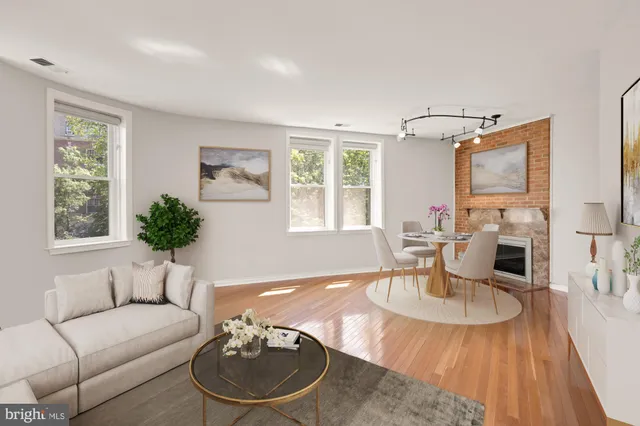 a living room with furniture a fireplace and large windows