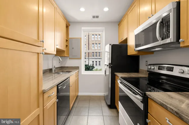 a kitchen with stainless steel appliances granite countertop a stove a refrigerator and a microwave