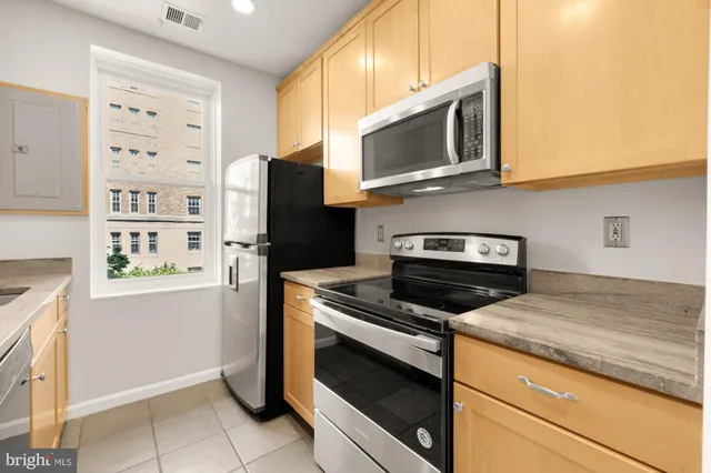 a kitchen with stainless steel appliances granite countertop a stove microwave and refrigerator