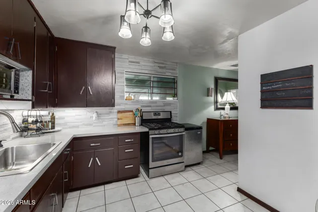 a kitchen with stainless steel appliances granite countertop a sink and stove top oven