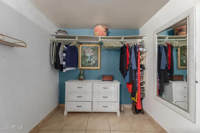 a view of walk in closet with clothes and shoes