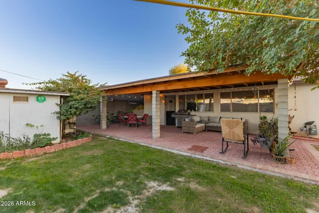 a backyard of a house with table and chairs