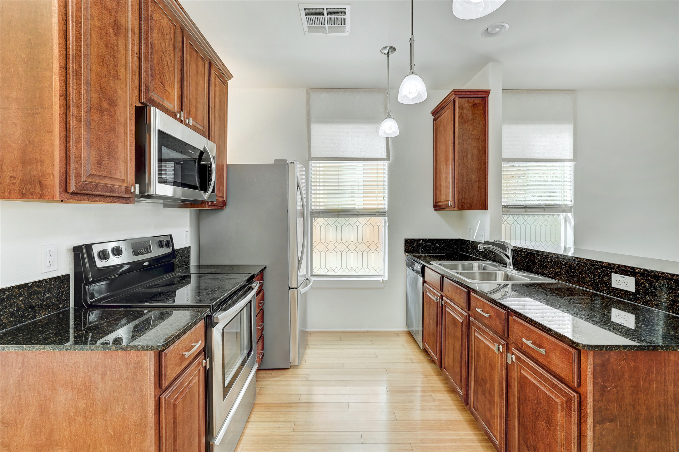 13420 Lyndhurst Street, Unit 208 Austin, TX 78717 - Photo 12 of 40 a kitchen with stainless steel appliances granite countertop a stove a sink and a microwave