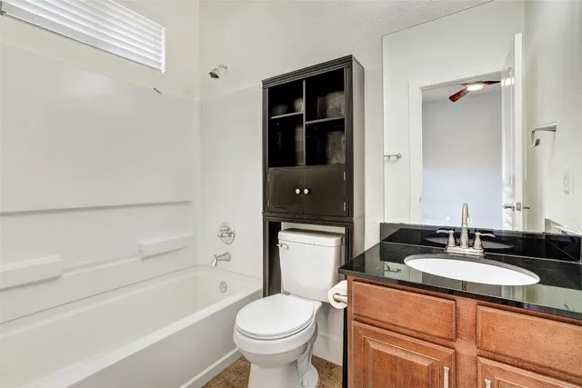 a bathroom with a granite countertop sink toilet and shower