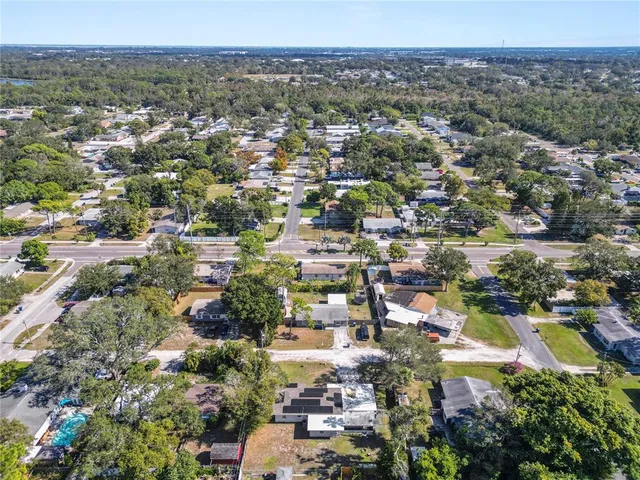 a backyard of a house with table and chairs under an umbrella