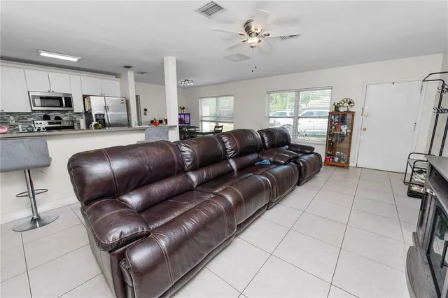 a living room with furniture and a view of kitchen