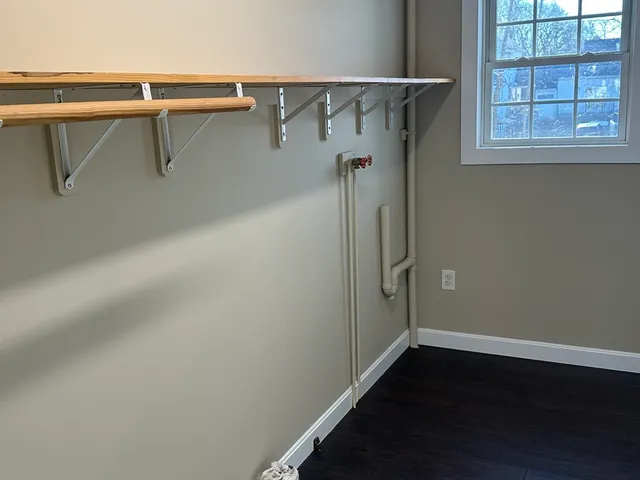 a view of a room with racks on the wall and a window