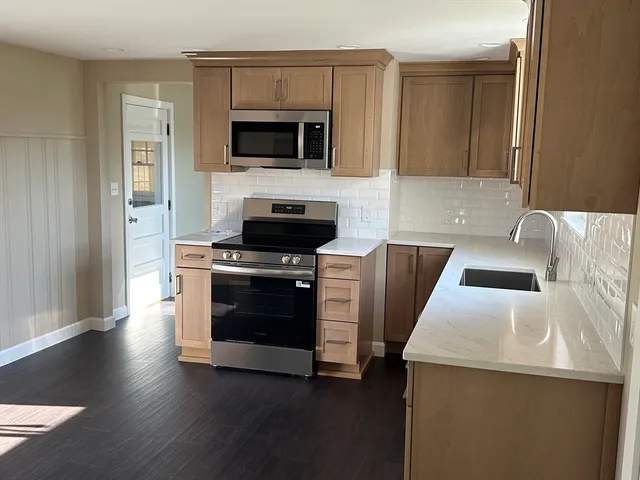 a kitchen with stainless steel appliances a stove microwave and sink