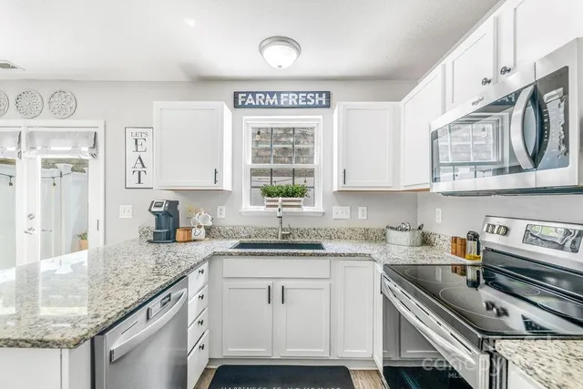 a kitchen with stainless steel appliances granite countertop a sink stove and cabinets