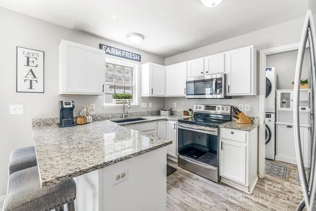 a kitchen with stainless steel appliances granite countertop a stove a sink and a microwave