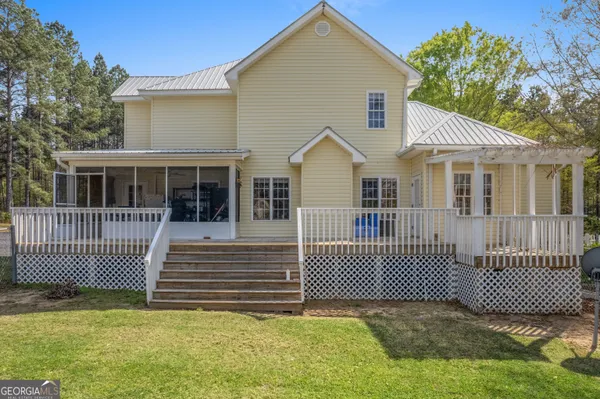 a view of a house with a fence and a yard