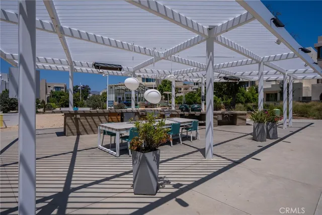 a view of a patio with a dining table and chairs under an umbrella
