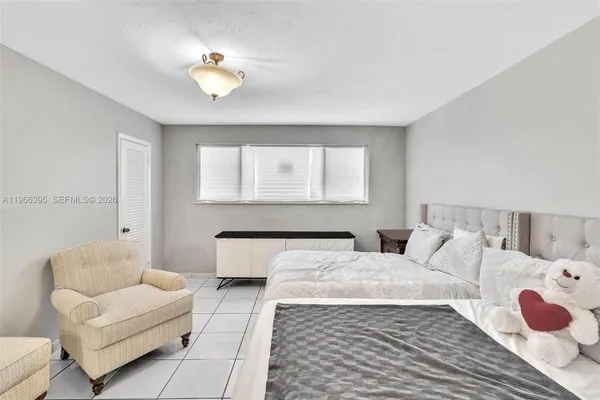 a bedroom with a bed couches chair and a chandelier