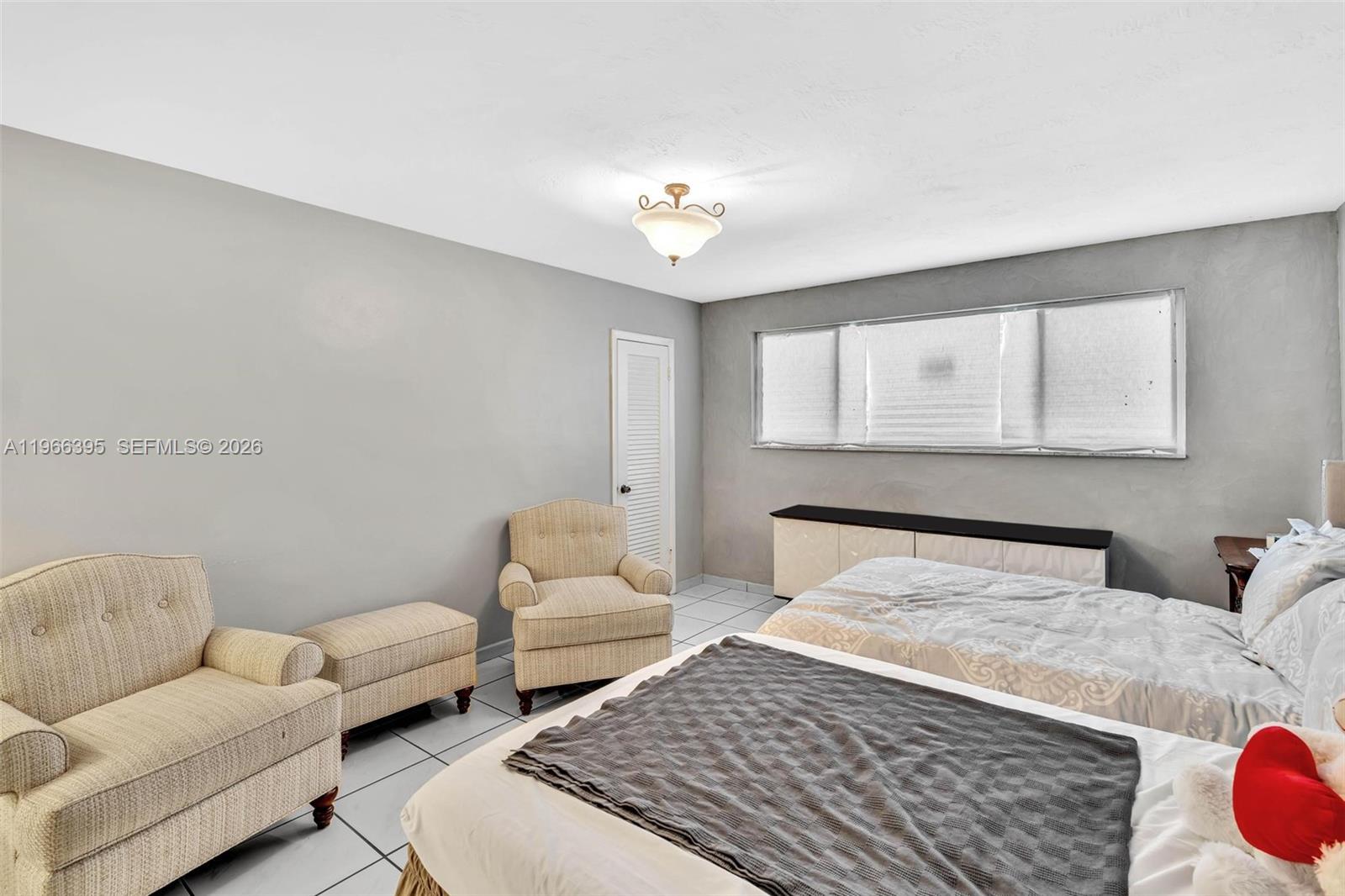 9524 Byron Avenue Surfside, FL 33154 - Photo 14 of 53 a bedroom with a bed couches chair and a chandelier