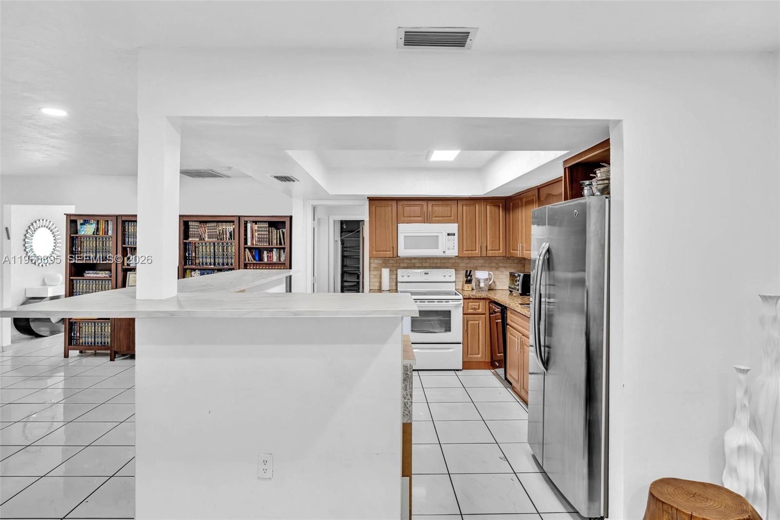 9524 Byron Avenue Surfside, FL 33154 - Photo 36 of 53 a large white kitchen with cabinets and stainless steel appliances