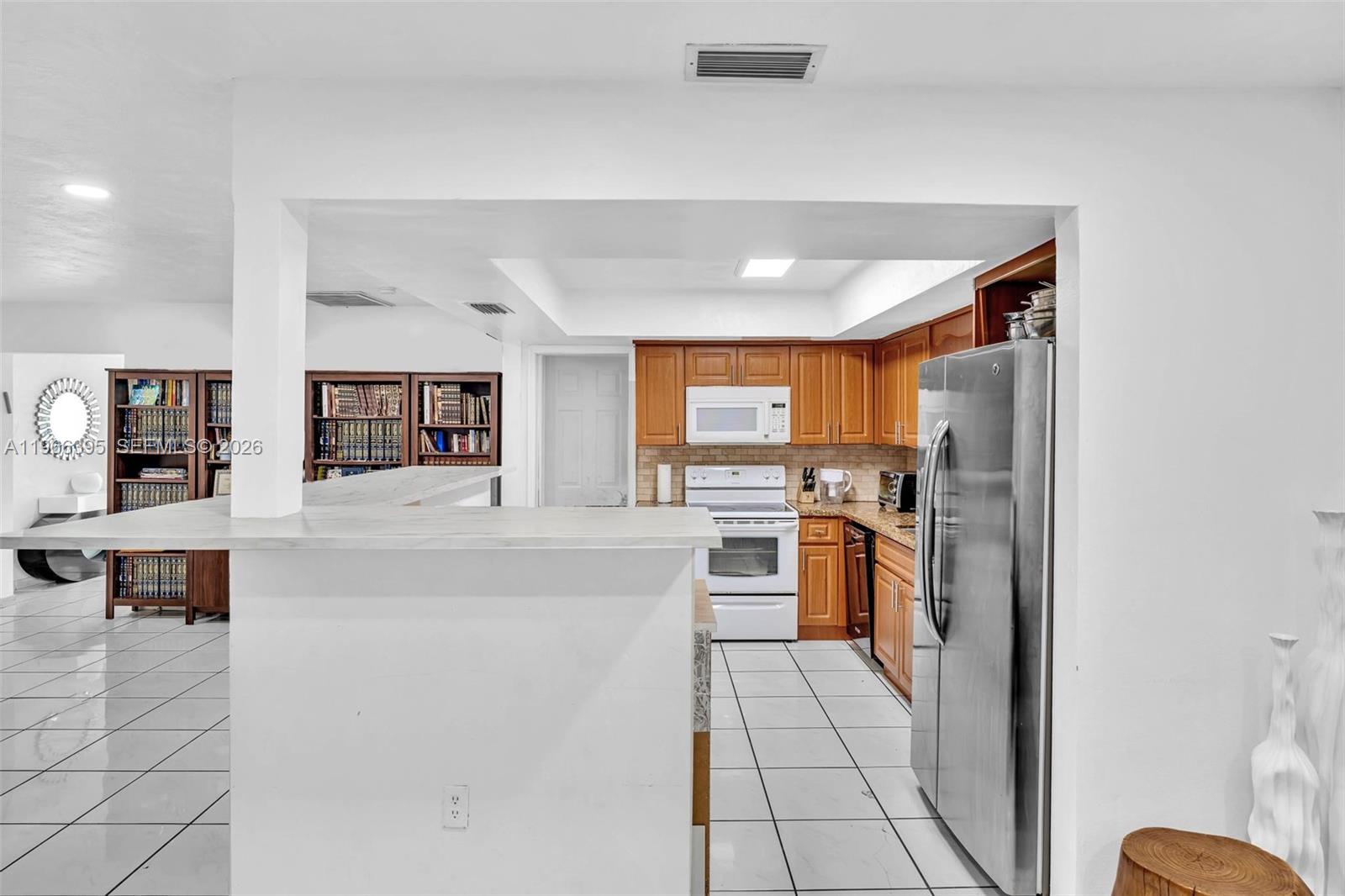 9524 Byron Avenue Surfside, FL 33154 - Photo 37 of 53 a kitchen with stainless steel appliances granite countertop a refrigerator and a stove top oven