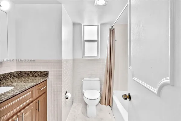 a bathroom with a granite countertop sink a toilet and a mirror