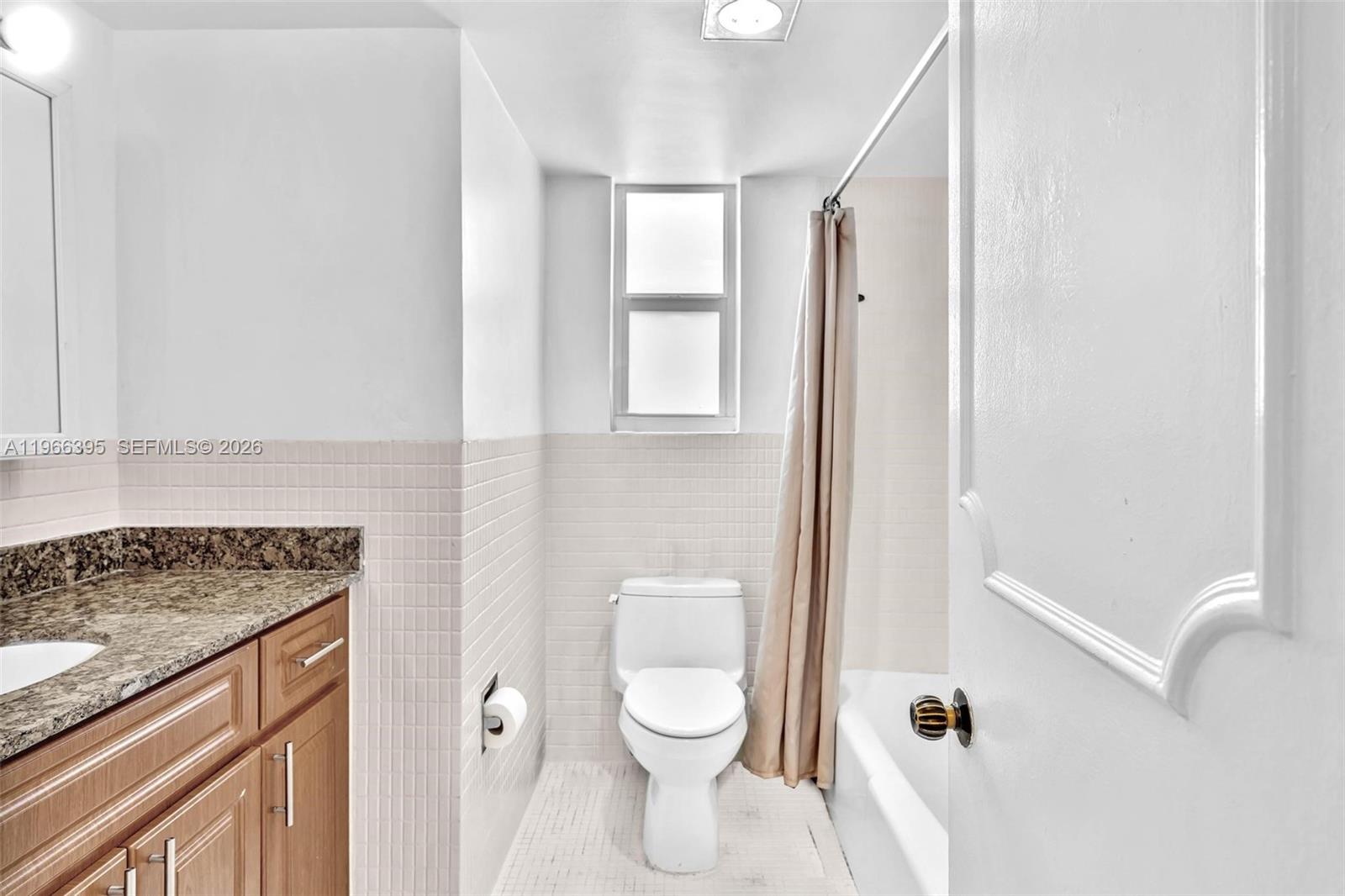 9524 Byron Avenue Surfside, FL 33154 - Photo 9 of 53 a bathroom with a granite countertop toilet a sink and a mirror