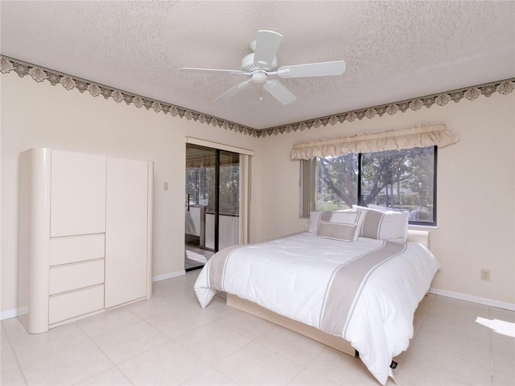 679 Racquet Club Road, Unit 4 Weston, FL 33326 - Photo 18 of 35 a bedroom with a large bed and a chandelier