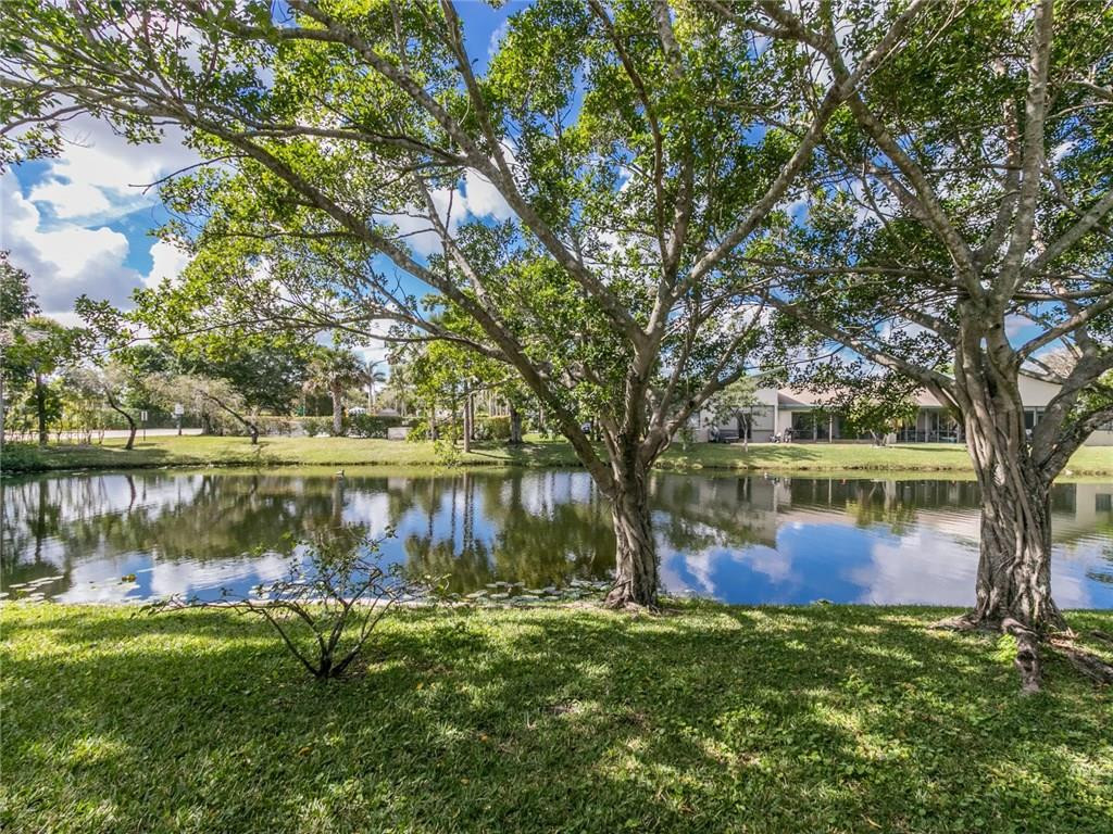 679 Racquet Club Road, Unit 4 Weston, FL 33326 - Photo 2 of 35 a view of a lake with a yard and large trees
