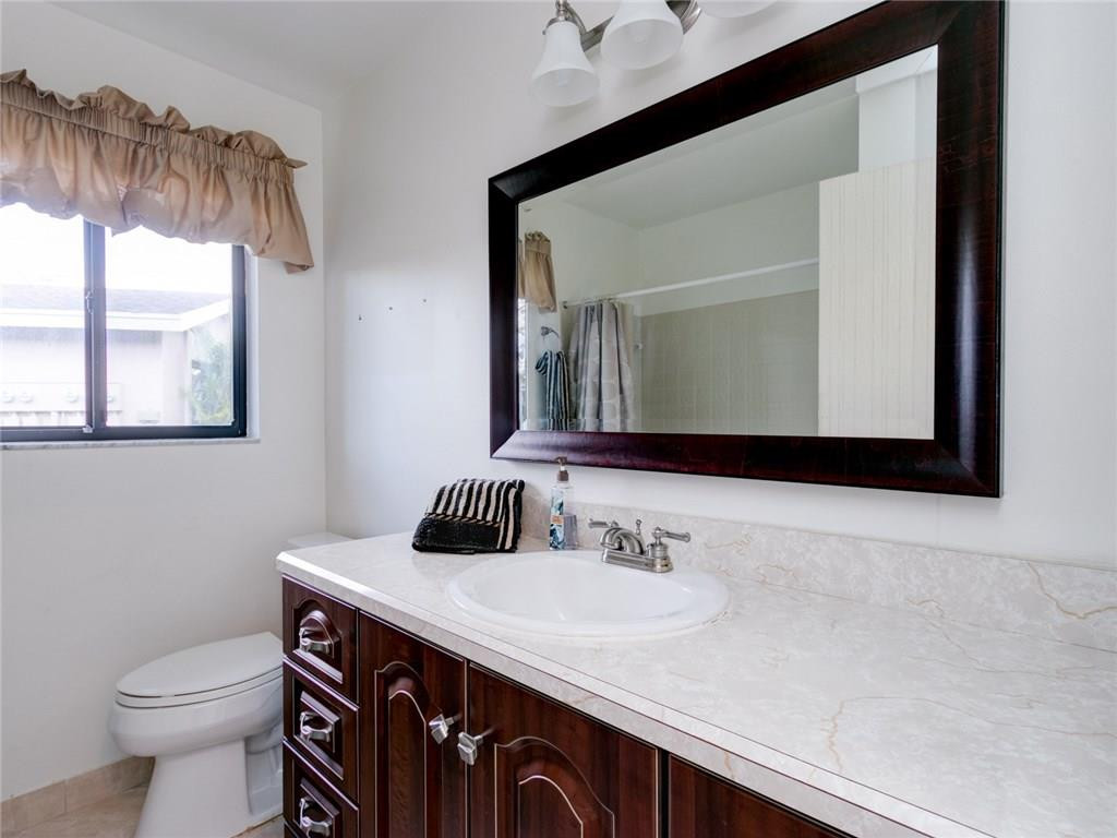 679 Racquet Club Road, Unit 4 Weston, FL 33326 - Photo 26 of 35 a bathroom with a sink vanity and a toilet