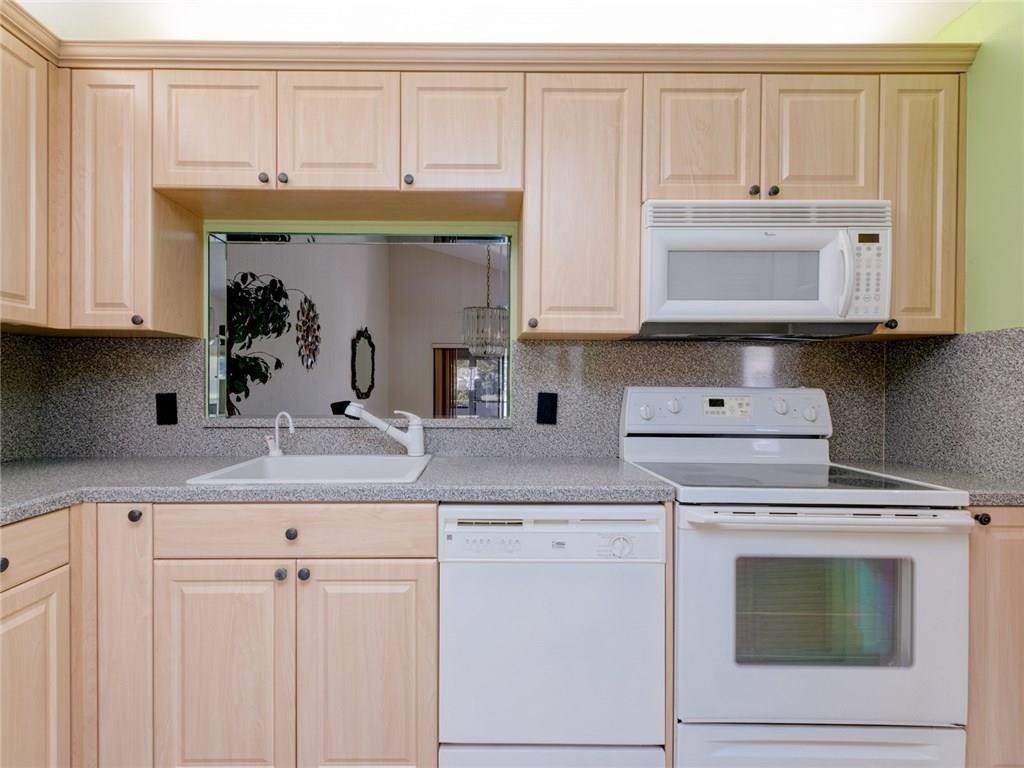 679 Racquet Club Road, Unit 4 Weston, FL 33326 - Photo 10 of 35 a kitchen with granite countertop white cabinets and white appliances