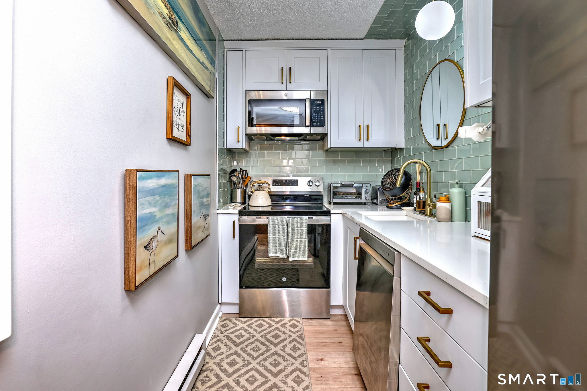 155 Short Beach Road, Unit 304 Stratford, CT 06615 - Photo 12 of 37 a kitchen with stainless steel appliances granite countertop a stove a sink and a microwave