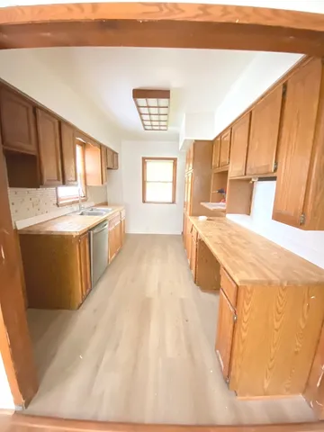 a large kitchen with stainless steel appliances a stove a sink dishwasher and a refrigerator