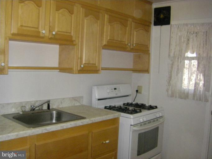 8429 Pleasant Plains Road Towson, MD 21286 - Photo 3 of 17 a kitchen with stainless steel appliances granite countertop a sink stove and cabinets