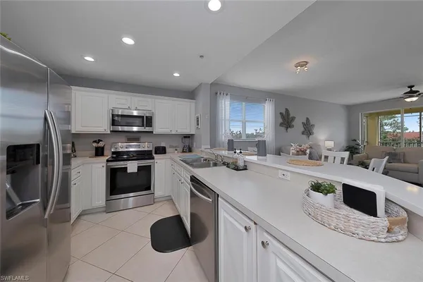 a kitchen with granite countertop a sink stainless steel appliances and cabinets