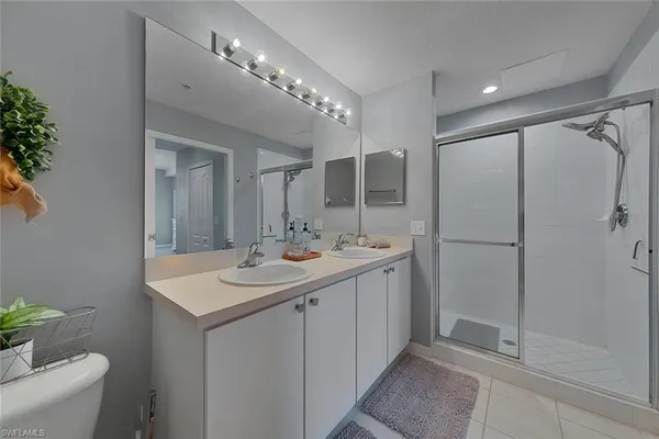 a bathroom with a sink shower and a mirror