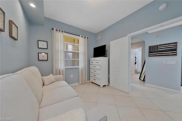 a living room with furniture a flat screen tv and a window