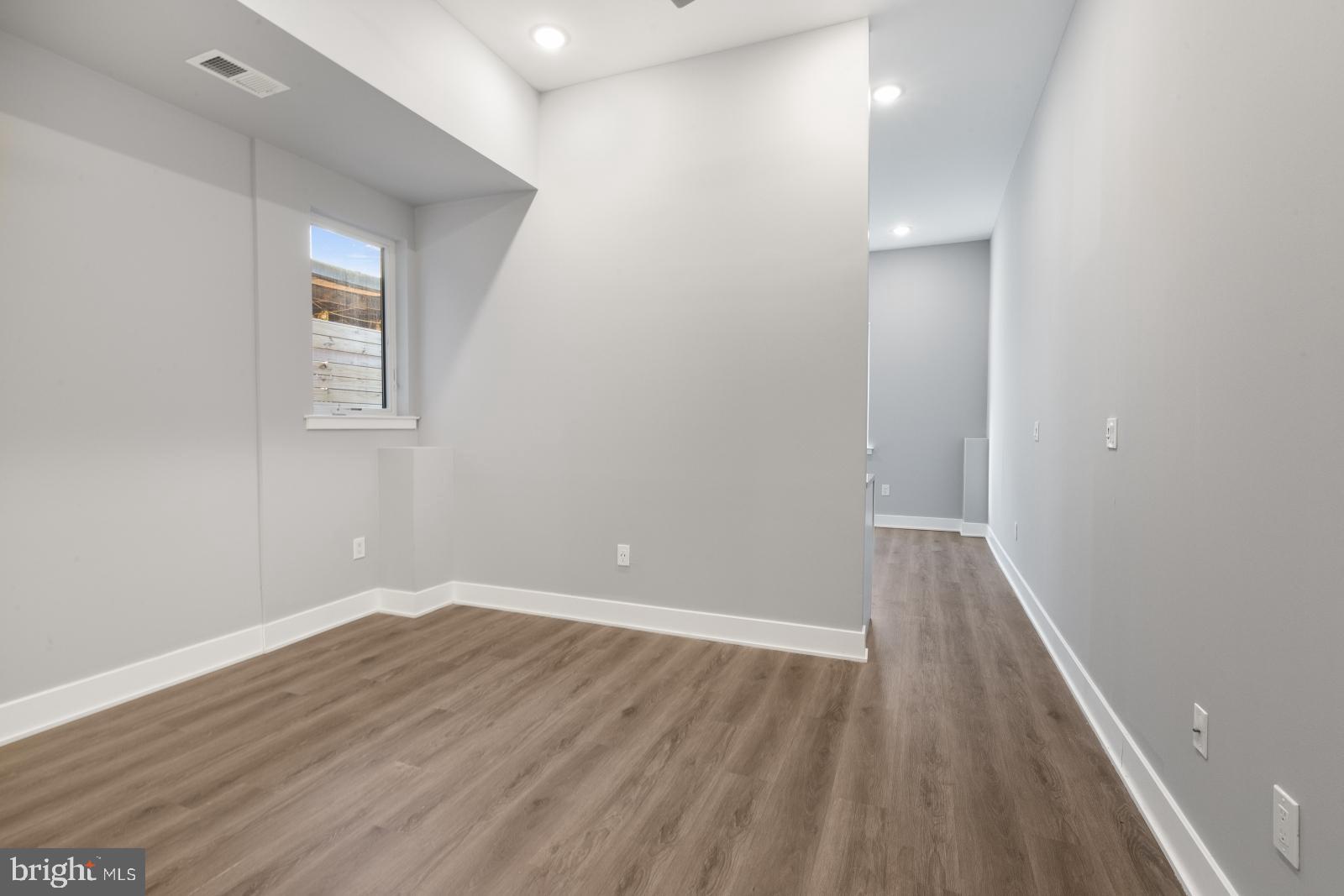 2119 North Front Street, Unit 101 Philadelphia, PA 19122 - Photo 11 of 23 wooden floor in an empty room with a window