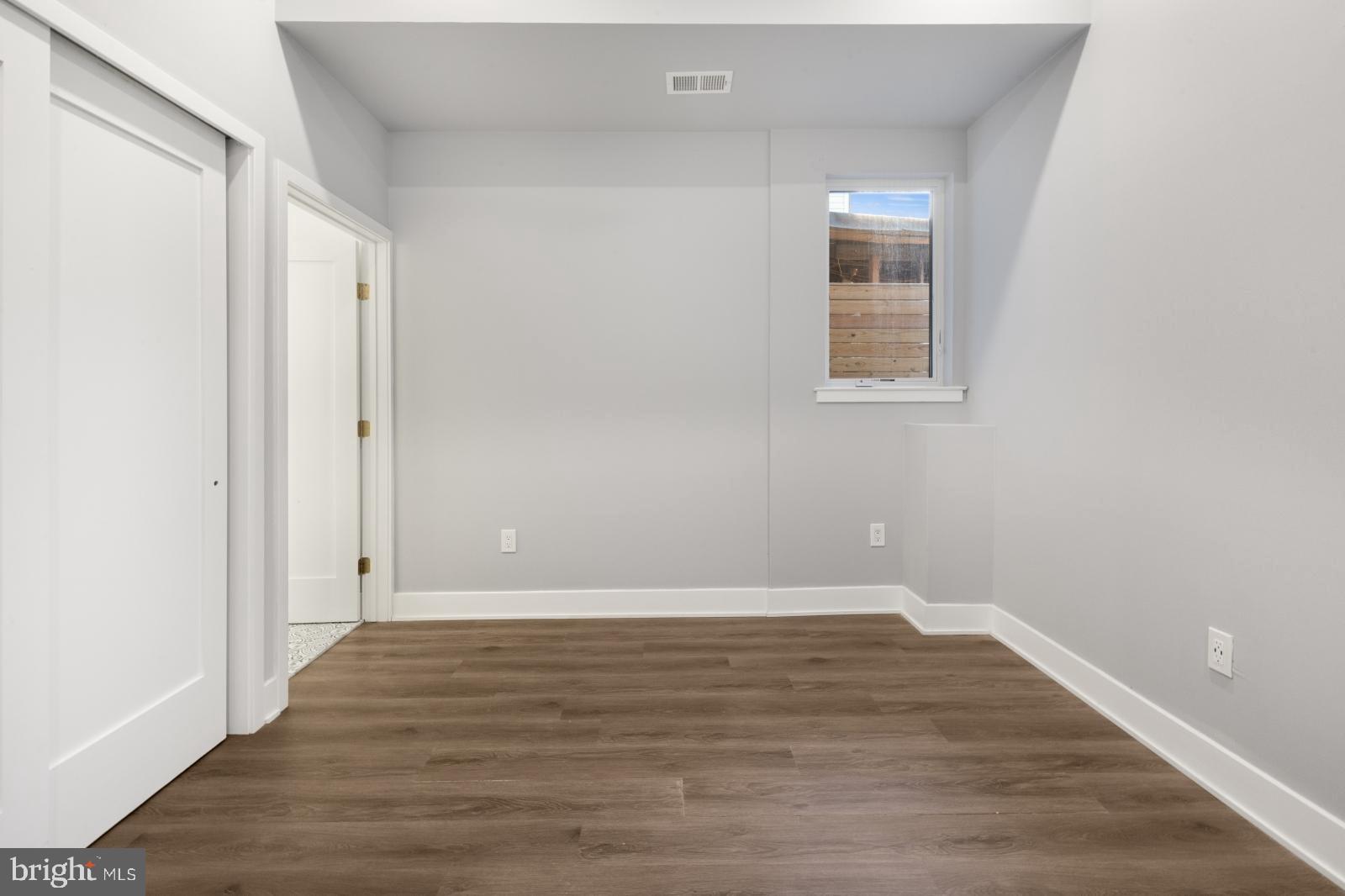 2119 North Front Street, Unit 101 Philadelphia, PA 19122 - Photo 12 of 23 a view of an empty room with wooden floor and a window
