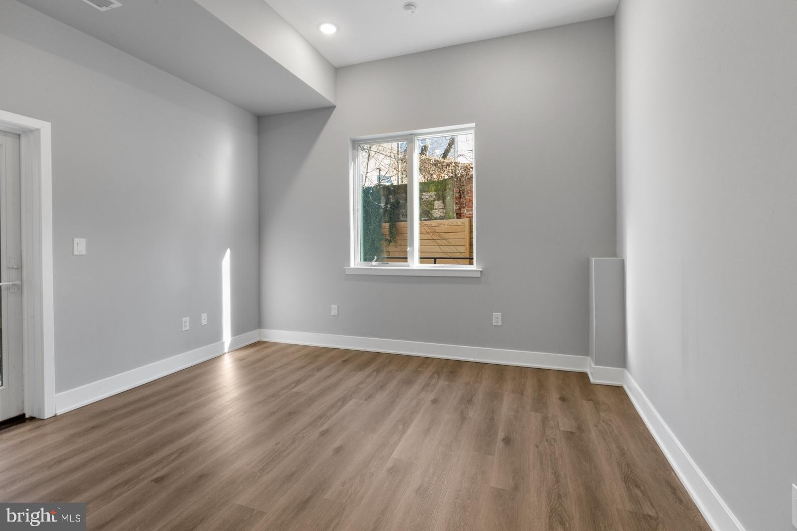 2119 North Front Street, Unit 101 Philadelphia, PA 19122 - Photo 2 of 23 an empty room with wooden floor and windows