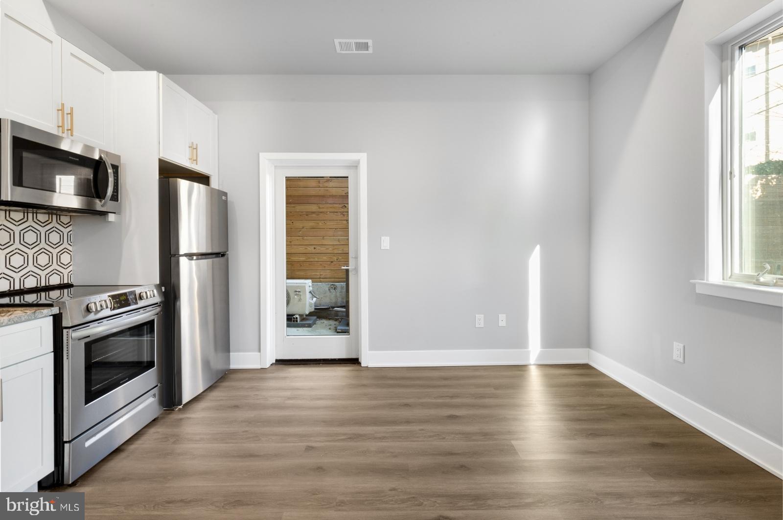 2119 North Front Street, Unit 101 Philadelphia, PA 19122 - Photo 3 of 23 a view of an empty room with a kitchen and a window