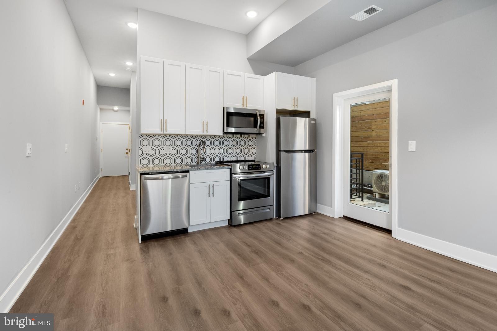 2119 North Front Street, Unit 101 Philadelphia, PA 19122 - Photo 4 of 23 a kitchen with stainless steel appliances granite countertop a stove a sink and a refrigerator