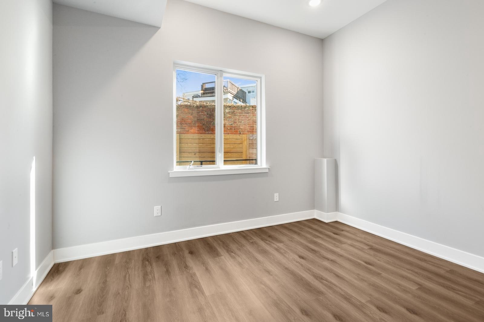 2119 North Front Street, Unit 101 Philadelphia, PA 19122 - Photo 6 of 23 an empty room with wooden floor and a window
