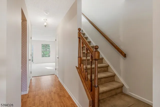 a view of a hallway with wooden floor and entryway
