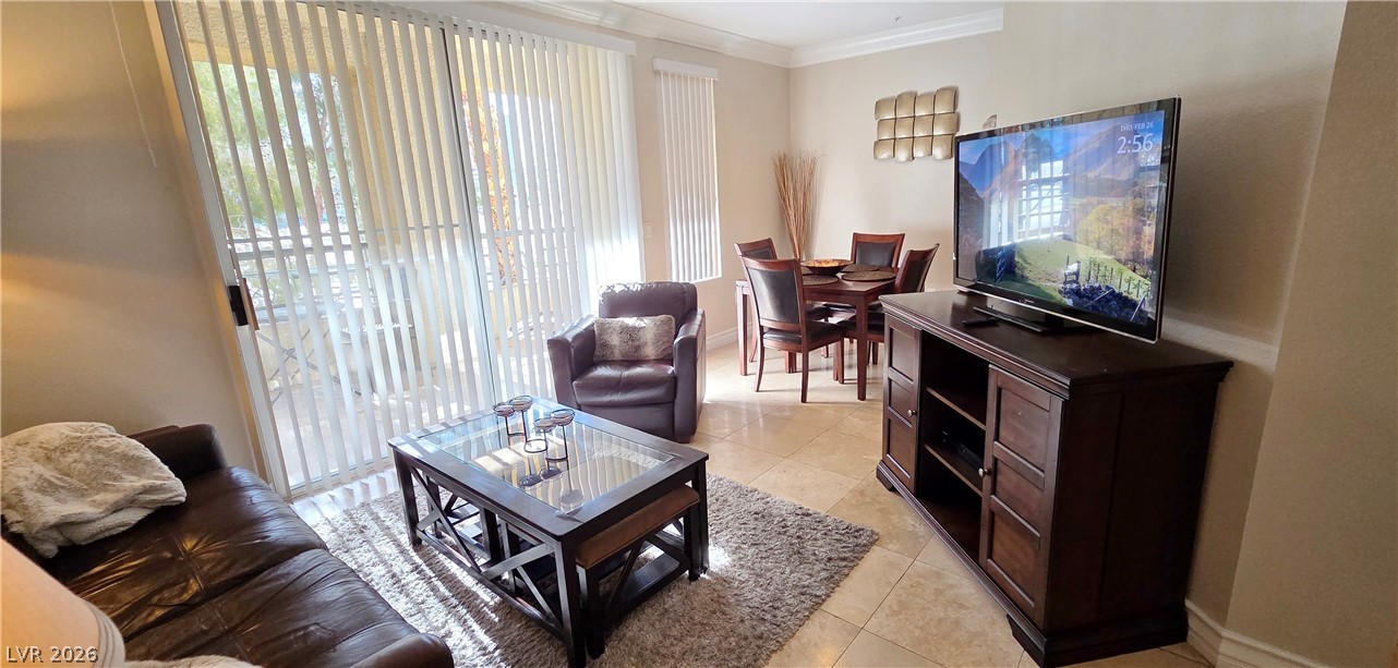 210 East Flamingo Road, Unit 208 Las Vegas, NV 89169 - Photo 7 of 42 Natural light floods this inviting living space, connecting to a dining area with elegant tiled flooring.