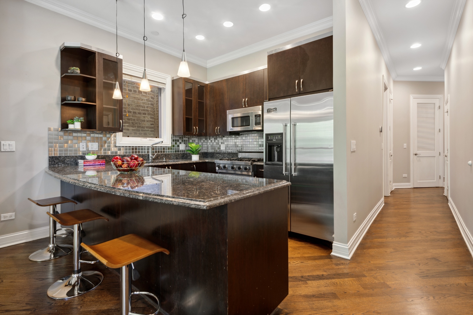 1131 West Addison Street, Unit 2 Chicago, IL 60613 - Photo 9 of 21 a kitchen with stainless steel appliances granite countertop a sink and a refrigerator